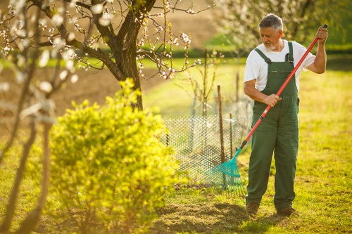 Landscape maintenance staff using safe machinery and PPE on site